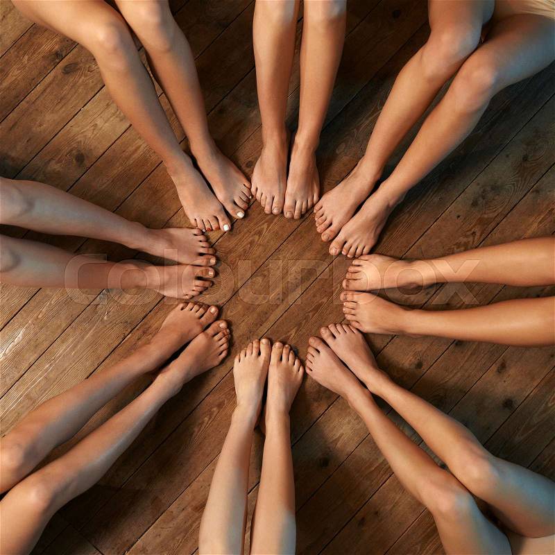 Feet of dancers seated circle on the floor, stock photo