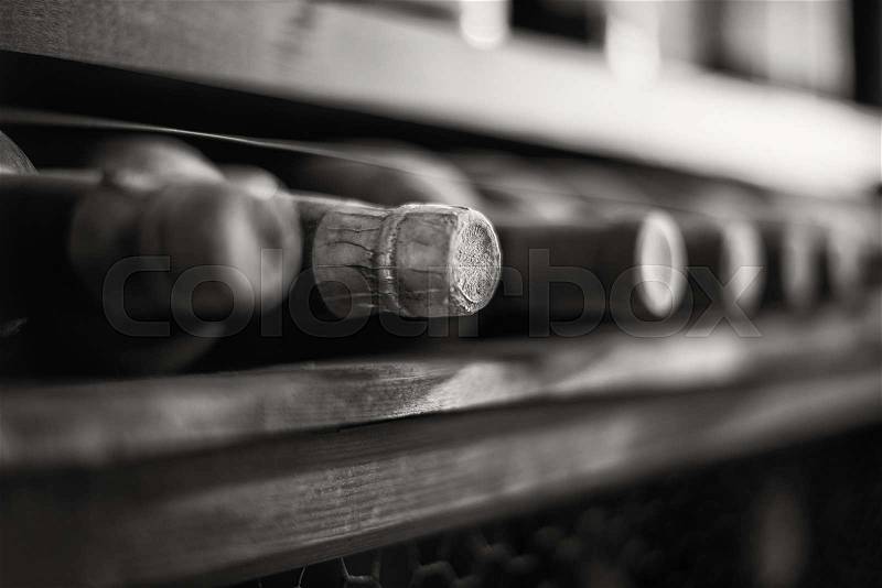 Wine bottles stacked on wooden racks. Black and white photo, stock photo