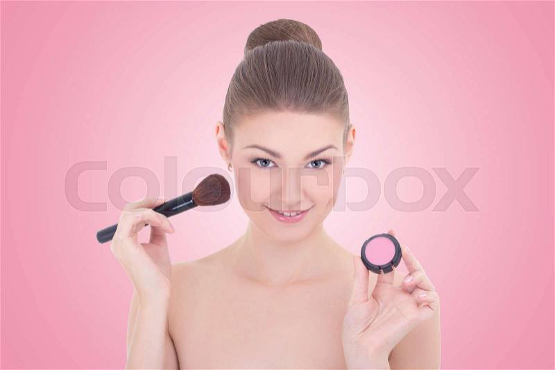 Portrait of young beautiful woman with make up brush and rouge or powder over pink background, stock photo