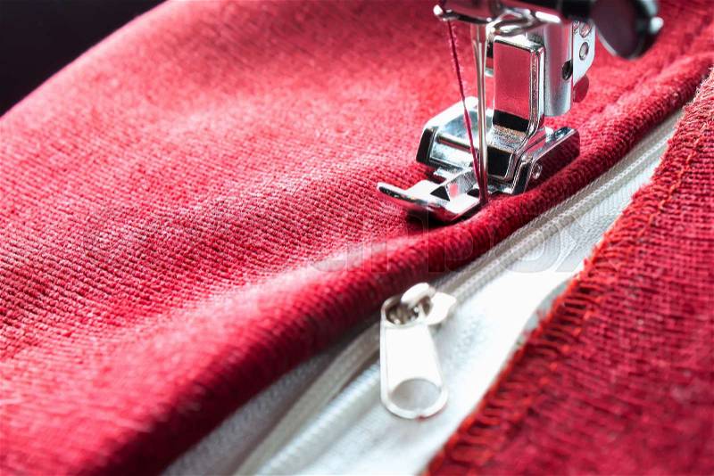 Sewing a white zipper on a sewing machine. sewing process, stock photo