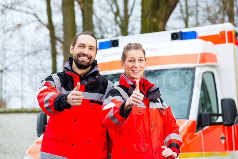 Emergency doctor and nurse standing in front of ambulance , stock photo