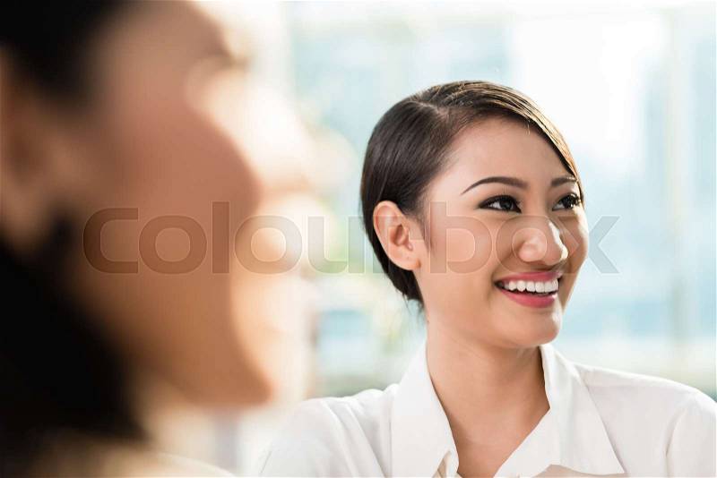 Chinese business woman in team meeting, stock photo