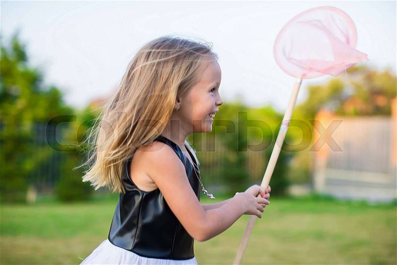 Adorable little girl catching butterflies butterfly net outdoors, stock photo