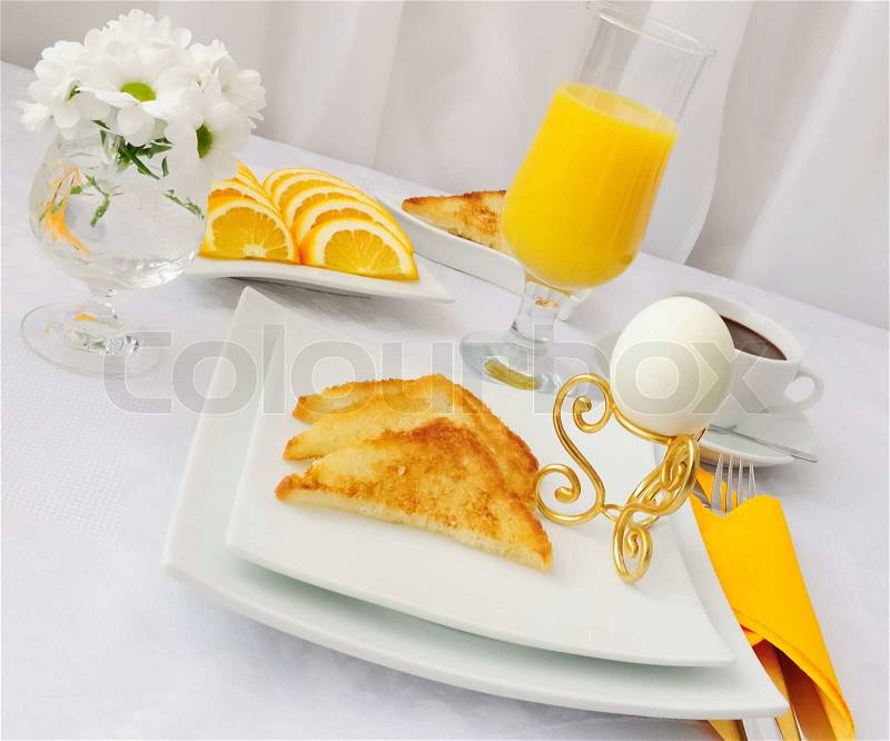 Breakfast with an egg on the pedestal of the dough with hot chocolate and orange juice, stock photo