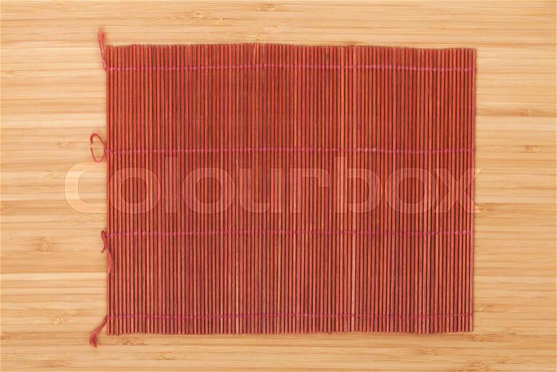 Japanese cooking mat over bamboo table with copy space, stock photo
