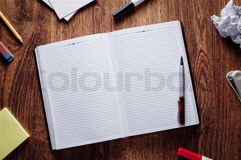 Close up Ballpoint Pen on Open Blank Notes, with Other Supplies on Sides, Placed on Wooden Table. Emphasizing Copy Space for Texts at the Center, stock photo