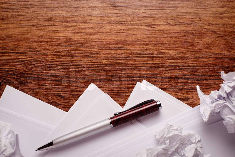 Conceptual Ballpoint Pen and Blank Sheets, with Crumpled Papers, Above Wooden Table with Copy Space on Top, stock photo
