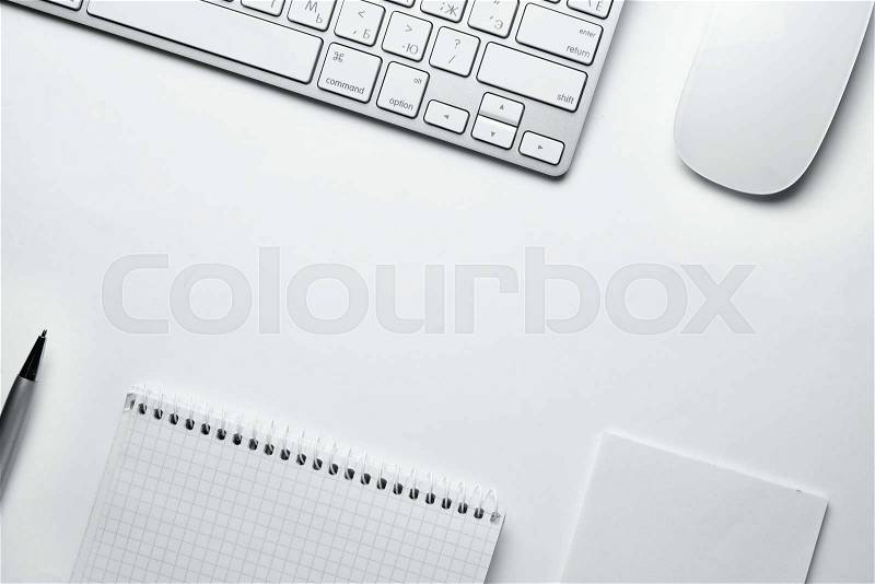 Conceptual White Ballpoint Pen, Clean Spiral Notes, Computer Keyboard and Mouse on Top of White Table with Copy Space at the Center, stock photo