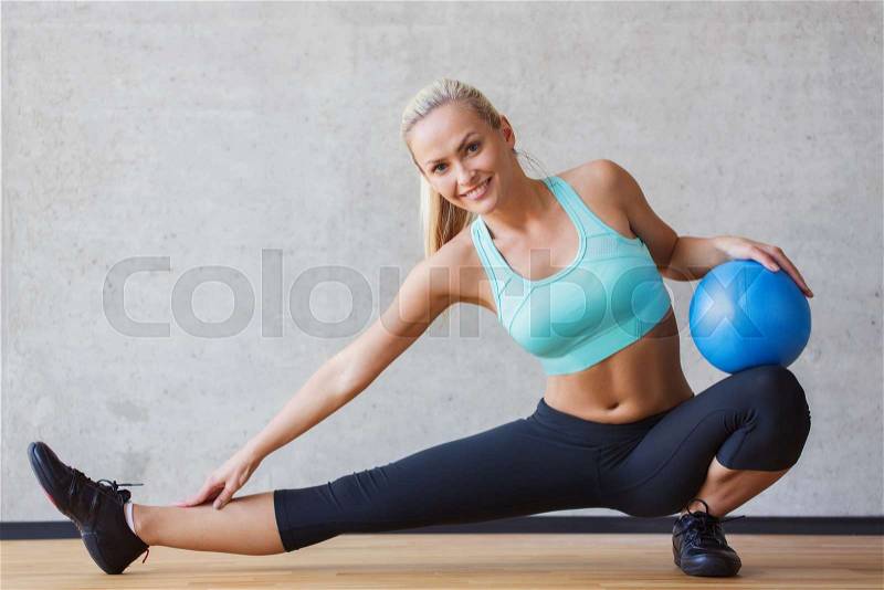 Fitness, sport, training and people concept - smiling woman with exercise ball in gym, stock photo