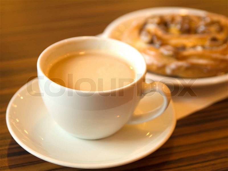 Morning coffee and cinnamon roll in cafe, stock photo