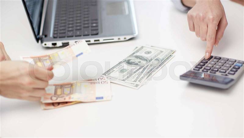 Finances, currency, exchange rate, technology and people concept - close up of hands counting dollar and euro money with calculator, stock photo