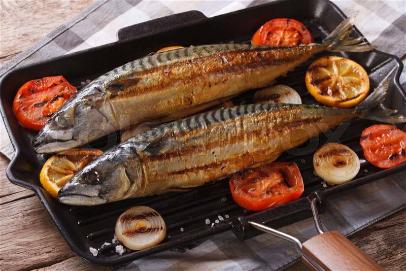 Grilled sea fish and vegetables in a pan grill closeup. horizontal , stock photo