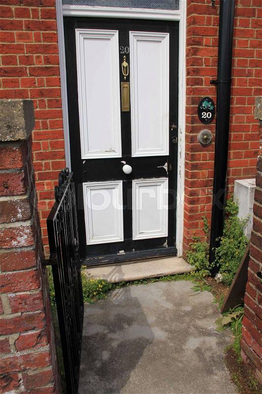 Front door with an iron fence in the residential area of Salisbury in England in the summer, stock photo