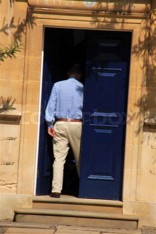 The teacher goes inside the University in the summer in Oxford in England, stock photo