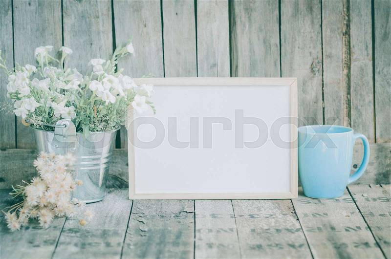 Vintage style White flowers stainless pot and blue pastel tea cup on wooden background, still life, stock photo