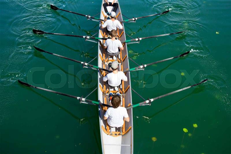 Boat coxed four team rowing on the tranquil lake, stock photo