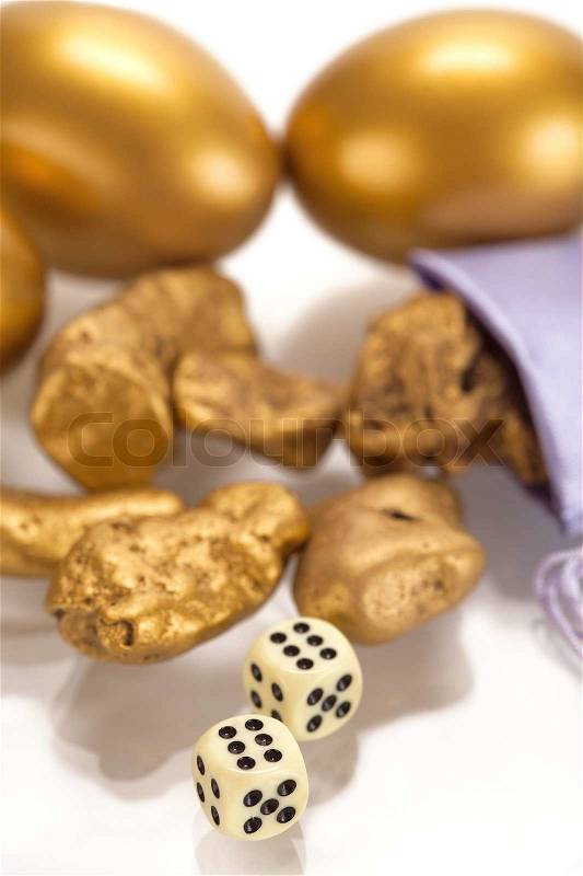 Nuggets of gold and a gold egg on a white background, stock photo