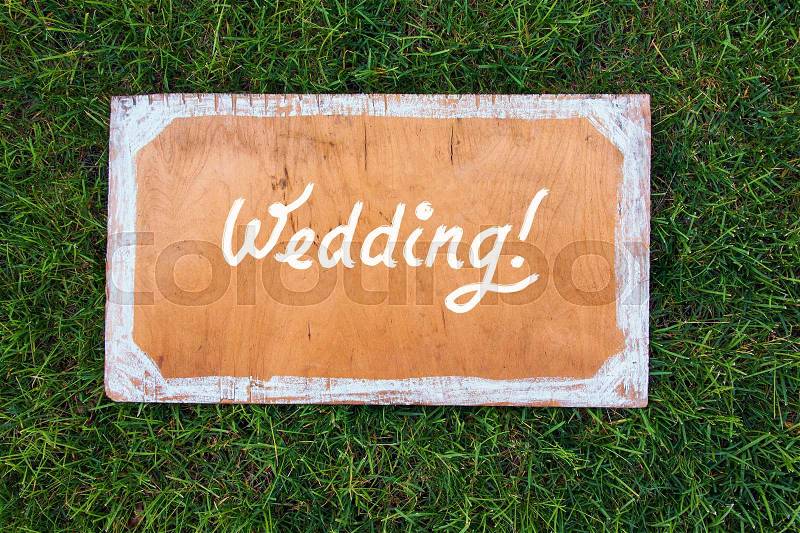 Wedding wooden sign on the grass. Spring or summer theme for ads, stock photo