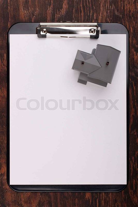 House model on a clipboard with white paper. Add your text to the paper, stock photo