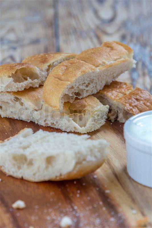 Flat bread sticks with Tzatziki garlic dip on a rustic wooden table, stock photo