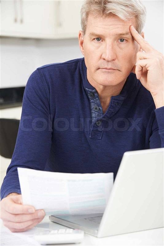 Worried Mature Man Looking Reviewing Finances At Home, stock photo