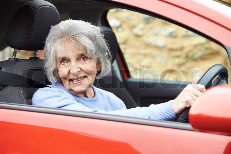 Portrait Of Smiling Senior Woman Driving Car, stock photo