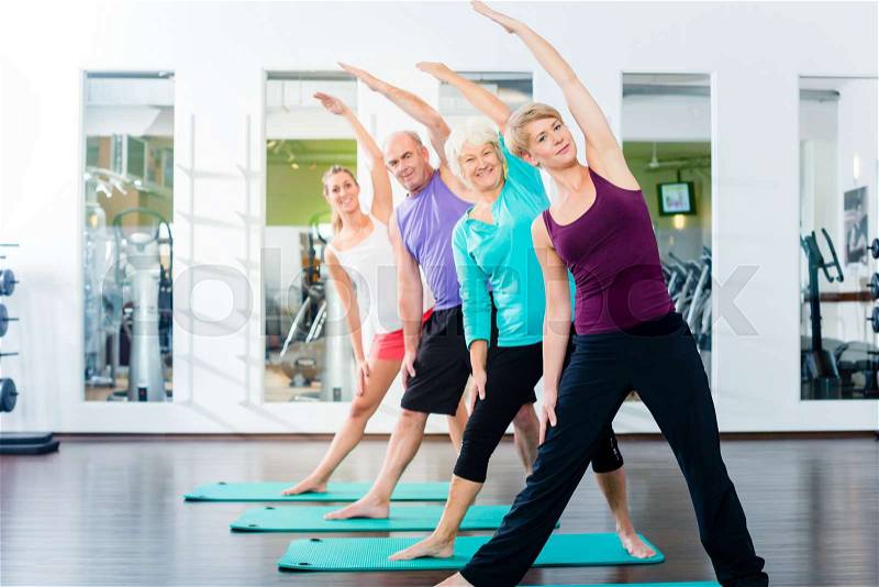 Group of senior people and young woman and men in fitness gym doing gymnastics , stock photo