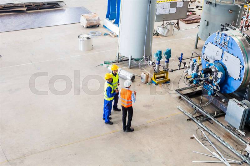 Industrial team of Worker and engineer discussing at machine in factory, stock photo