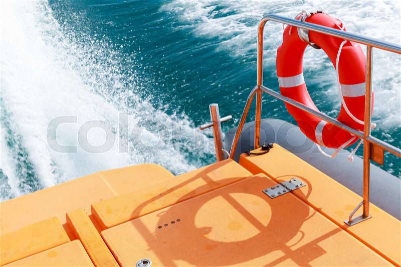 Red lifebuoy hanging on steel railings of safety rescue boat, stock photo