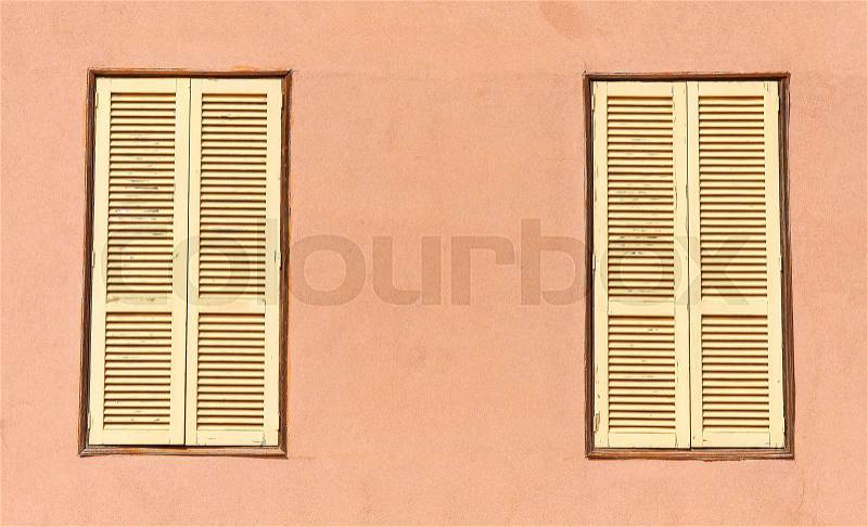 Two window with yellow shutters. Close-up view, stock photo