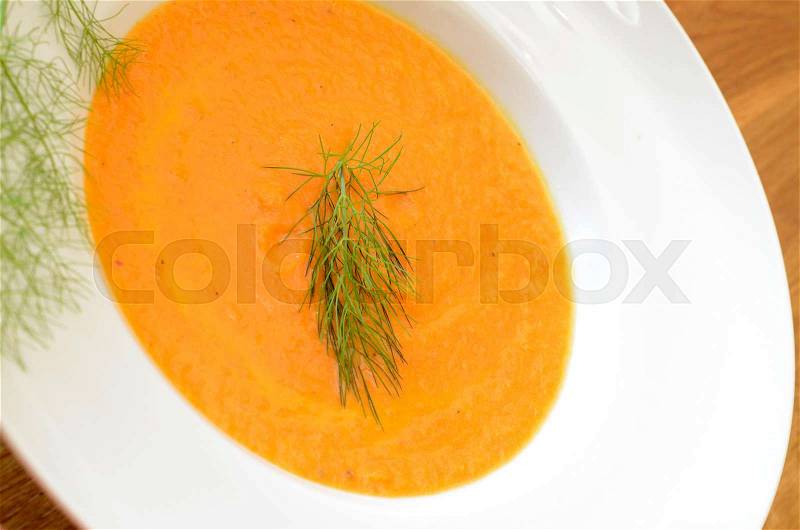 Carrot soup on a wooden table, stock photo