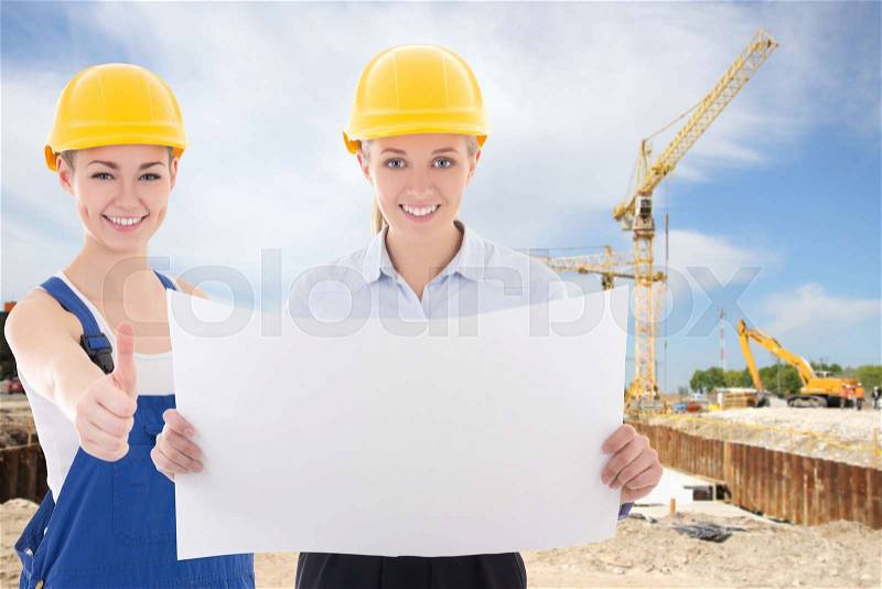 Business women architect and builder in yellow helmet at construction site, stock photo