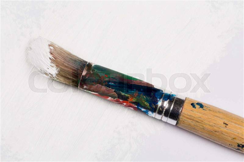 Used paint brush in white color on white paper, stock photo