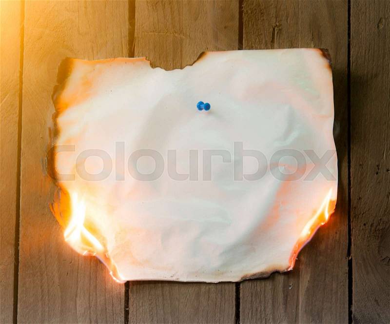Fire paper on wooden background, stock photo