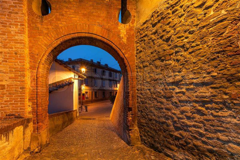 Old brick arch and stone wall as part of medieval castle in town of Barolo in Piedmont, Northern Italy, stock photo