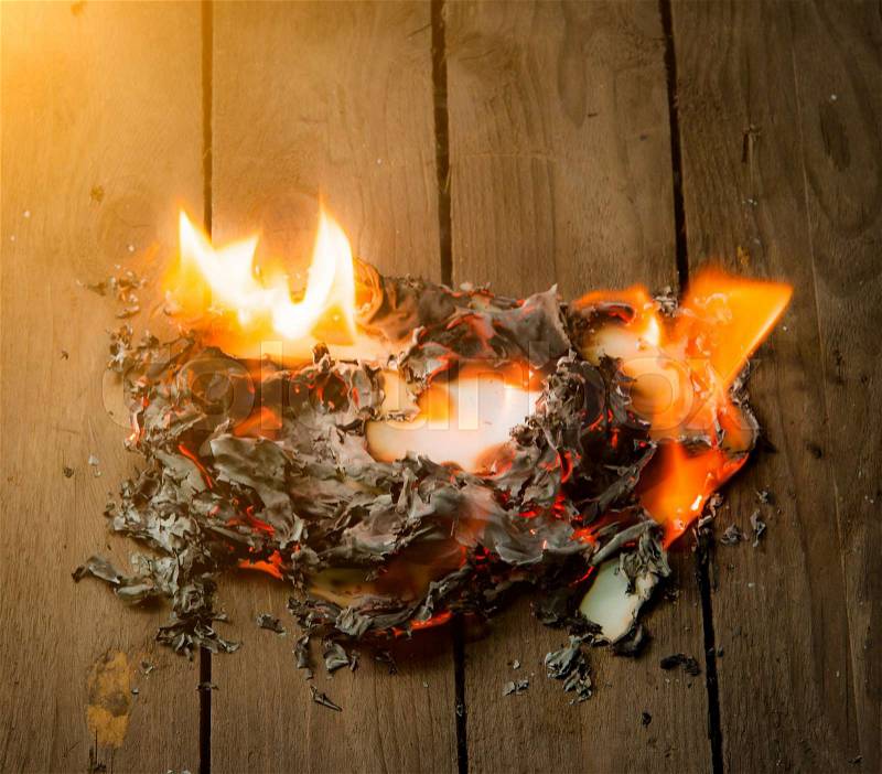 Fire paper on wooden background, stock photo