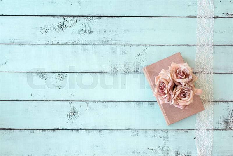 Old books with lace, rose and keys on shabby chic mint background, top view point, stock photo