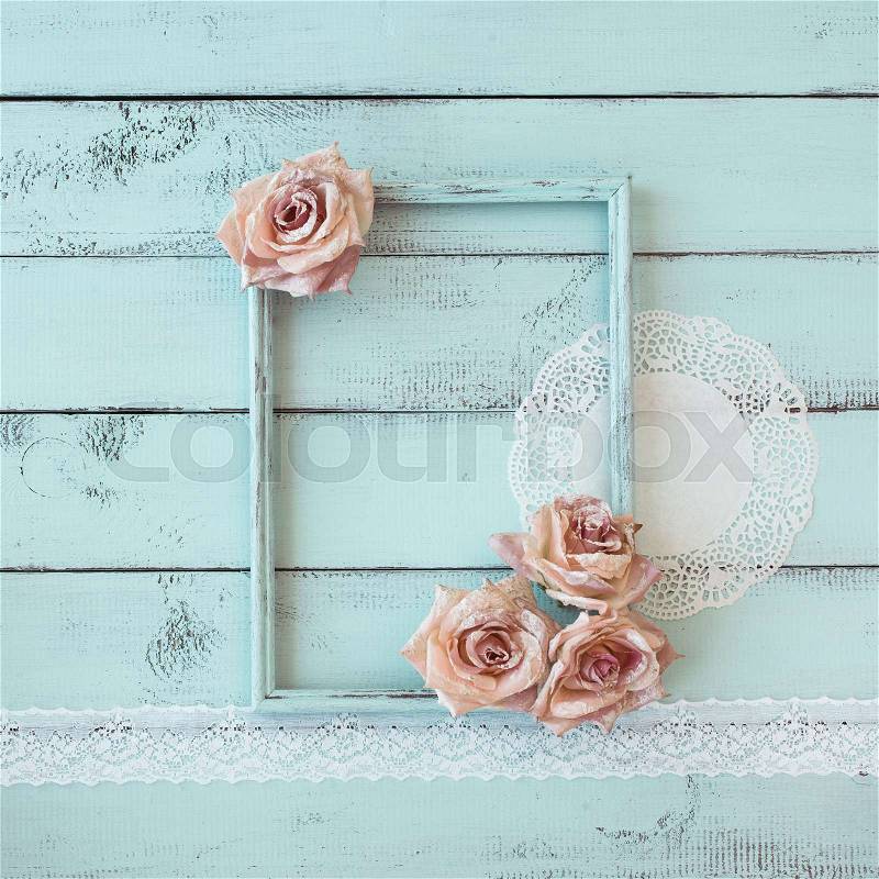 Wooden photo frame with lace and flowers on mint shabby chic background, stock photo