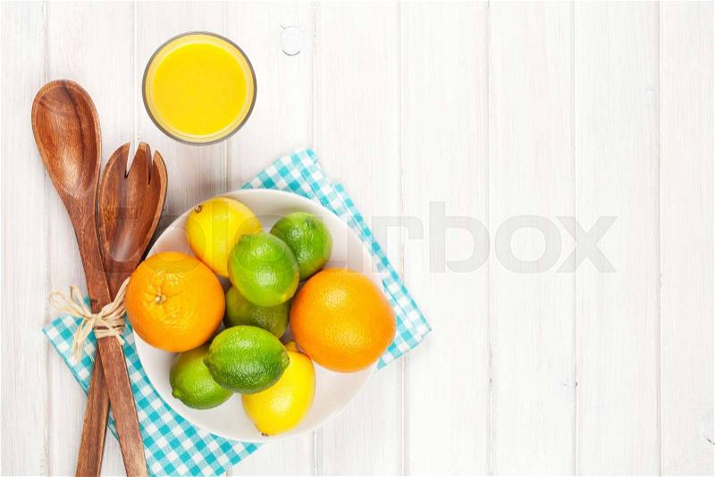 Citrus fruits. Oranges, limes and lemons and orange juice. Over wooden table background with copy space, stock photo