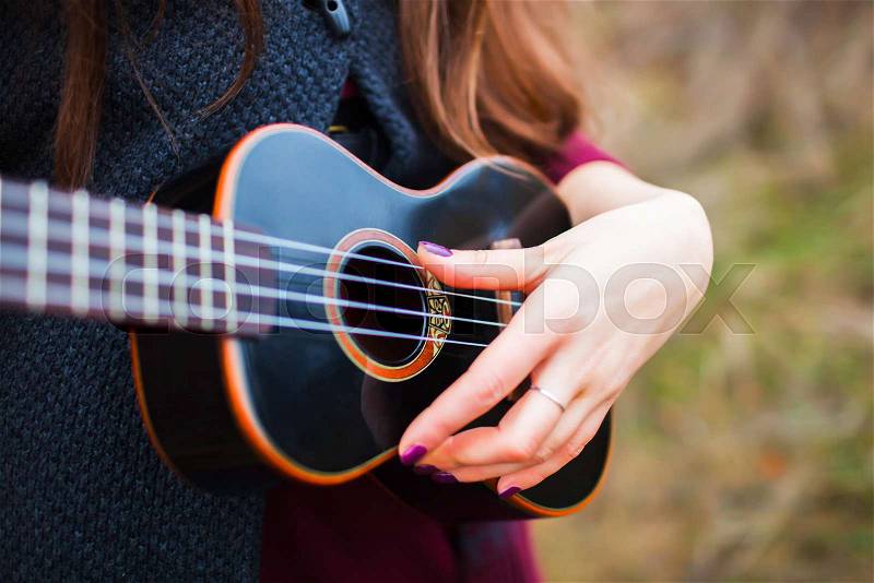 Girl playing the guitar, stock photo