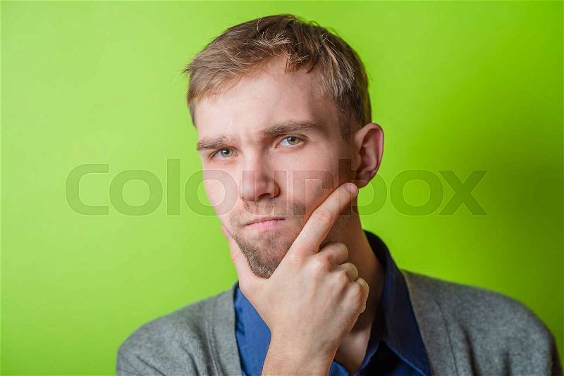 Young man chin resting on his hands with an intent sincere expression, stock photo