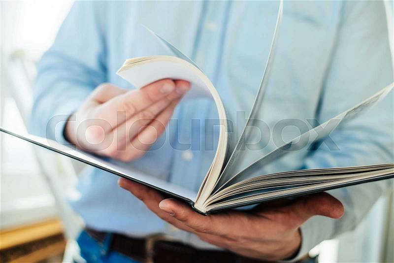 Closeup on a man reading a magazine. Tinted, stock photo
