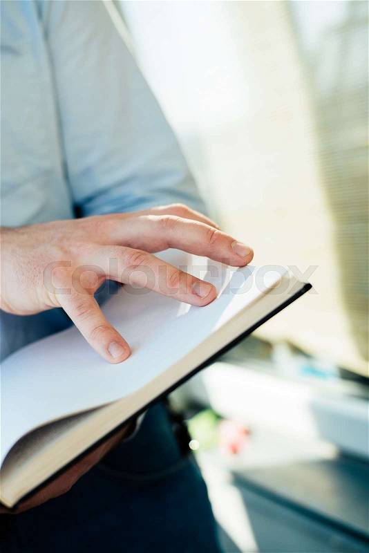 Closeup on a man reading a magazine. Tinted, stock photo