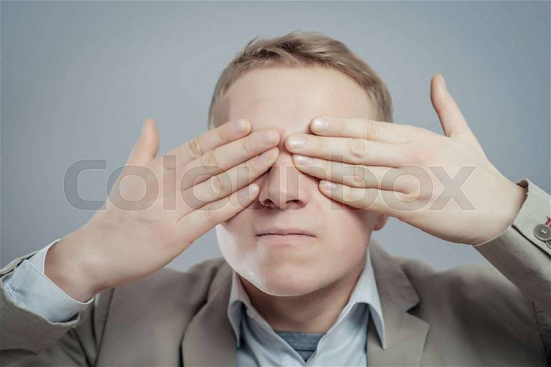 Portrait Of An Businessman Covering Eyes Isolated On Grey Background, stock photo