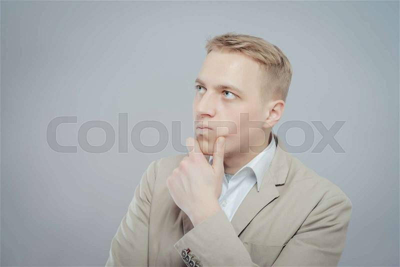 Thinking man . Closeup portrait of a casual young pensive businessman looking up at , stock photo
