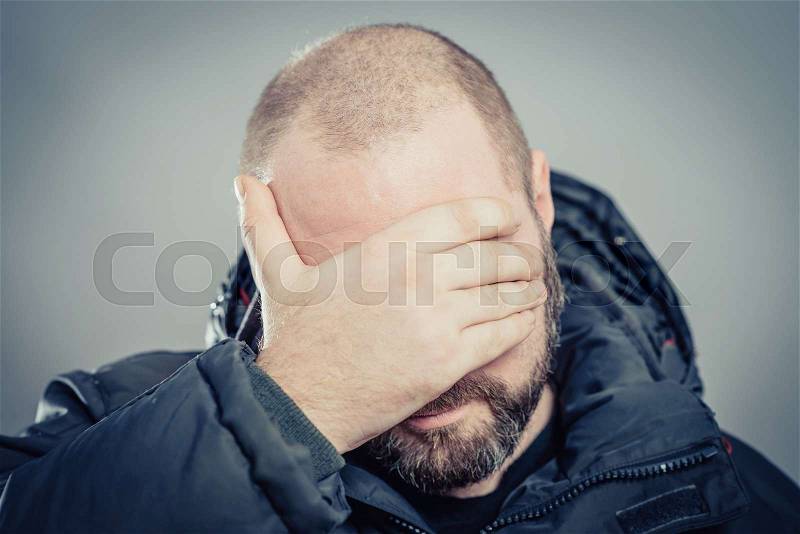 Young man closed eyes his hand, stock photo