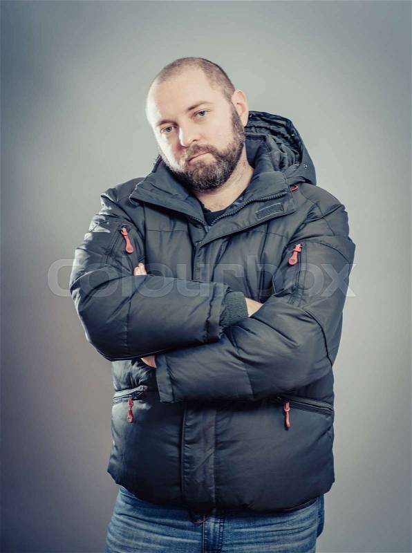 Serious man with hands folded on grey background, stock photo