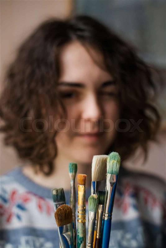 Girl holding a brush oil, stock photo