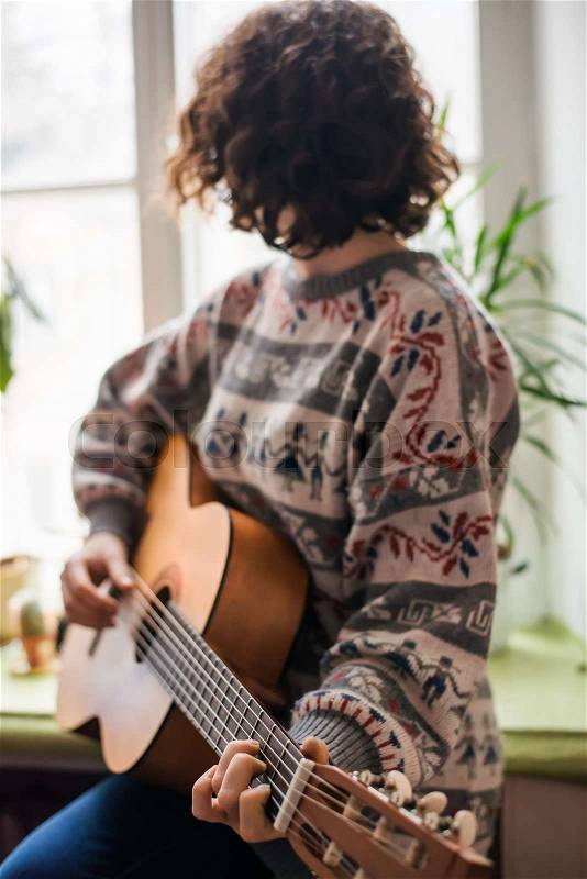 Teenage girl playing the guitar , stock photo