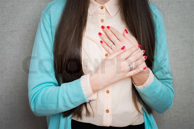 Woman feeling heart pain and holding her chest, stock photo